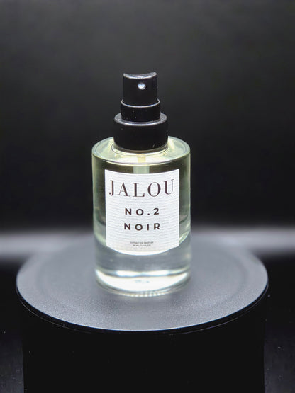 JALOU NO. 2 NOIR Extrait de Parfum – Detailansicht des Flakons auf schwarzem Podest vor dunklem Hintergrund.