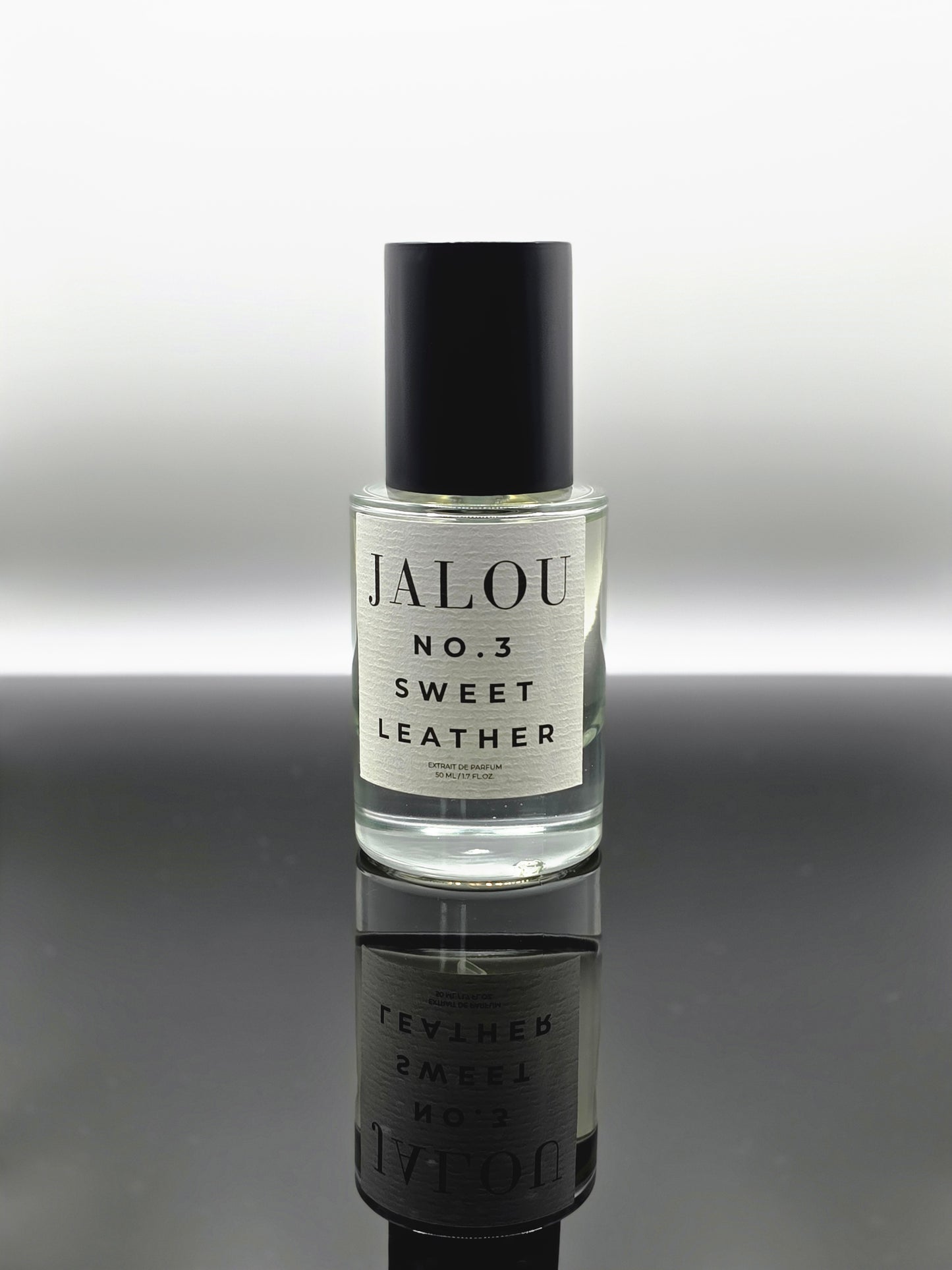 JALOU NO. 3 SWEET LEATHER – 50ml Extrait de Parfum Flakon auf einer spiegelnden schwarzen Oberfläche.