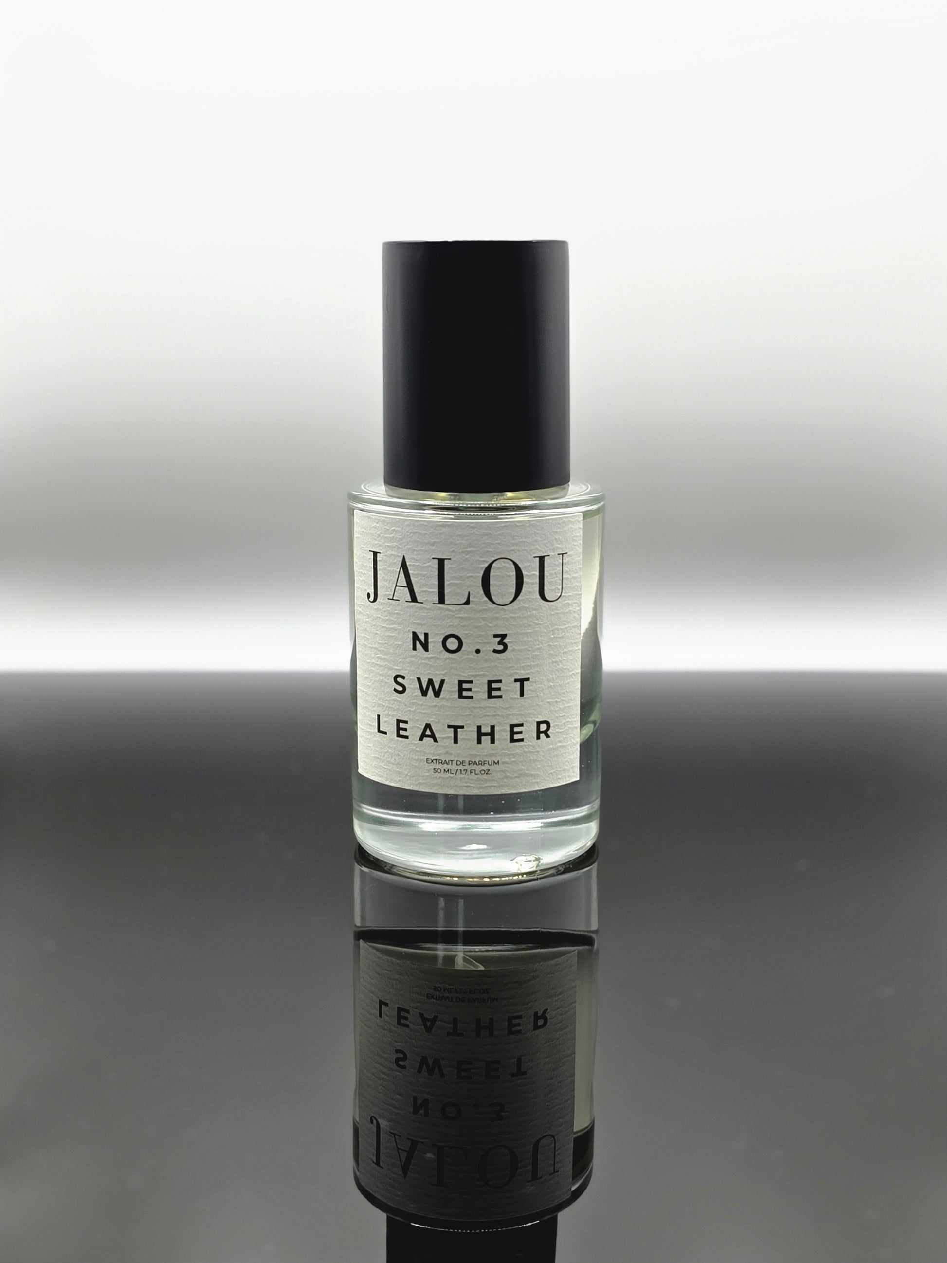 JALOU NO. 3 SWEET LEATHER – 50ml Extrait de Parfum Flakon auf einer spiegelnden schwarzen Oberfläche.
