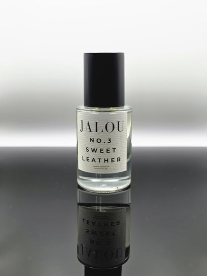 JALOU NO. 3 SWEET LEATHER – 50ml Extrait de Parfum Flakon auf einer spiegelnden schwarzen Oberfläche.